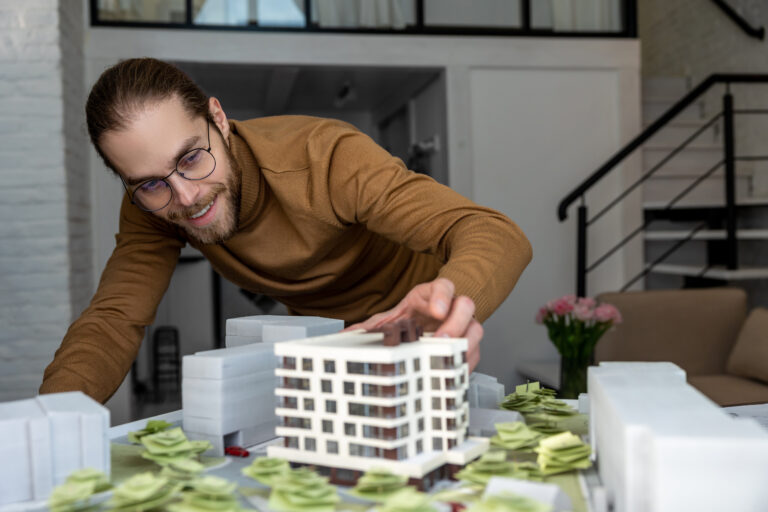 Ein Archtiekt der Wohnungswirtschaft arbeitet im Büro an der Gestaltung eines neuen Wohnkomplexes, entwirft das Layout der Gebäude